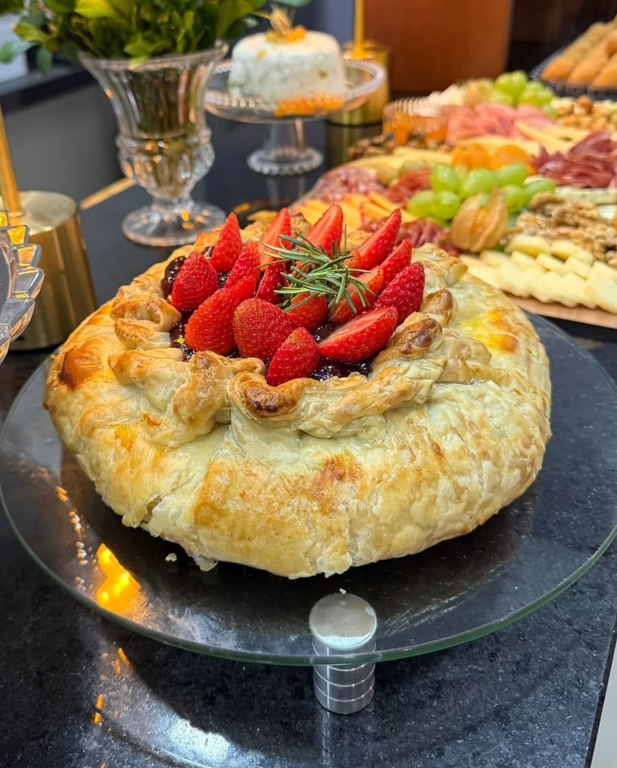 Brie folhado dourado coberto com morangos e geleia de frutas vermelhas