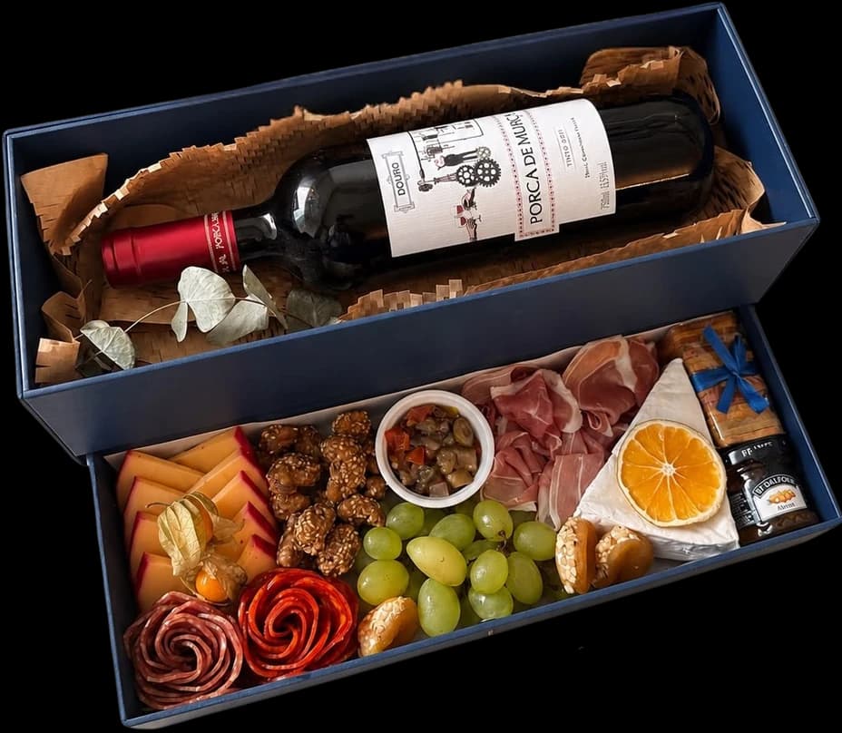 Caixa cartonada com gaveta, vinho tinto, frios, frutas e castanhas